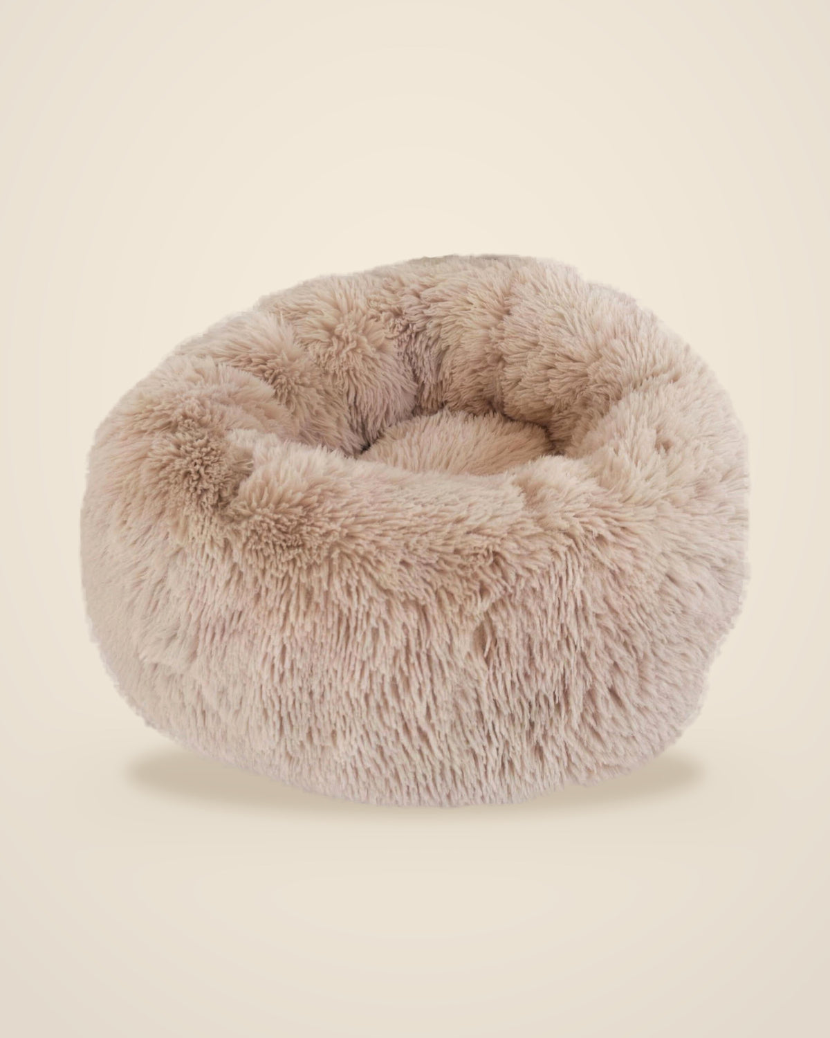 The DenKind Calm Bed in oat, a round long-pile plush bed with a raised rim