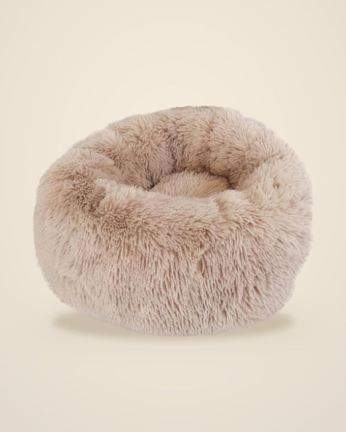 The DenKind Calm Bed in oat, a round long-pile plush bed with a raised rim